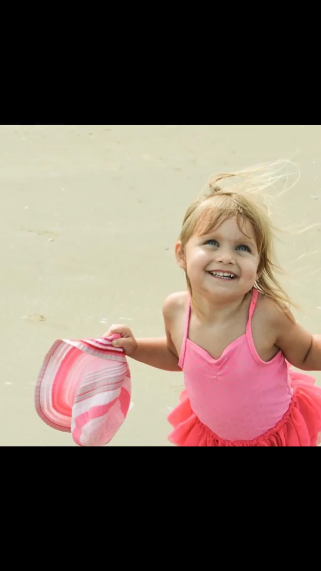 Joyful Moments at the Beach: A Little Girl's Delight in Pink and Sunshine
