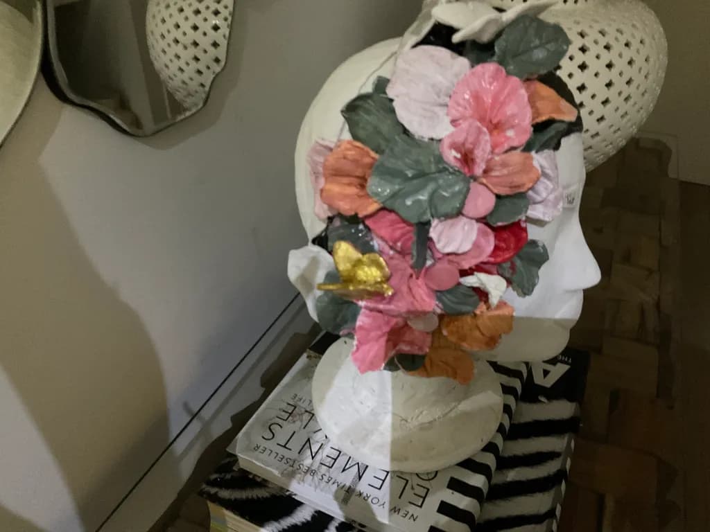 Floral Reverie: A Whimsical Sculpture Adorning a Bust with Vibrant Blossoms and Golden Accents