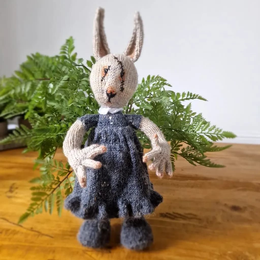 Whimsical Hand-Knitted Rabbit Doll in Charming Dress with Fern Backdrop