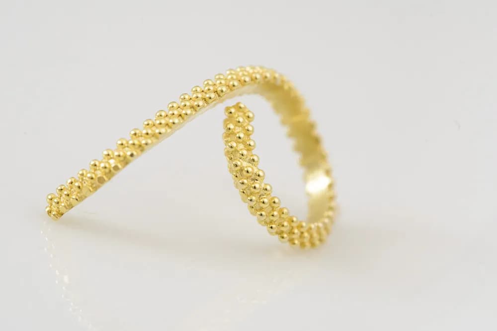 Golden Elegance: A Twisted Ring of Radiant Beads