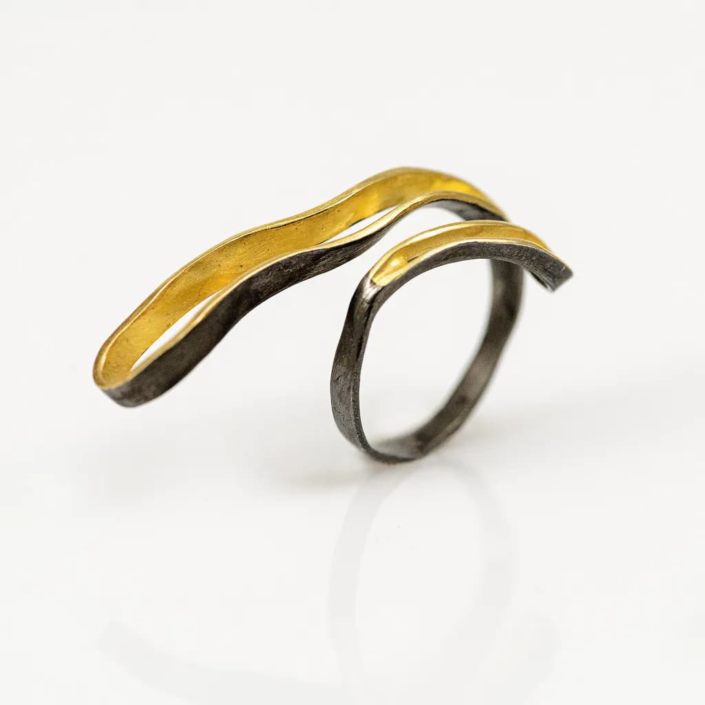 Elegant Wave Ring: A Fusion of Gold and Dark Metal Artistry