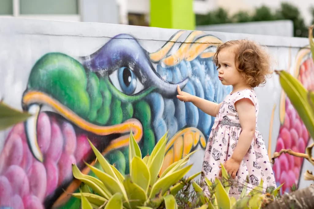 Whimsical Wonder: A Child's Curiosity Meets Vibrant Street Art