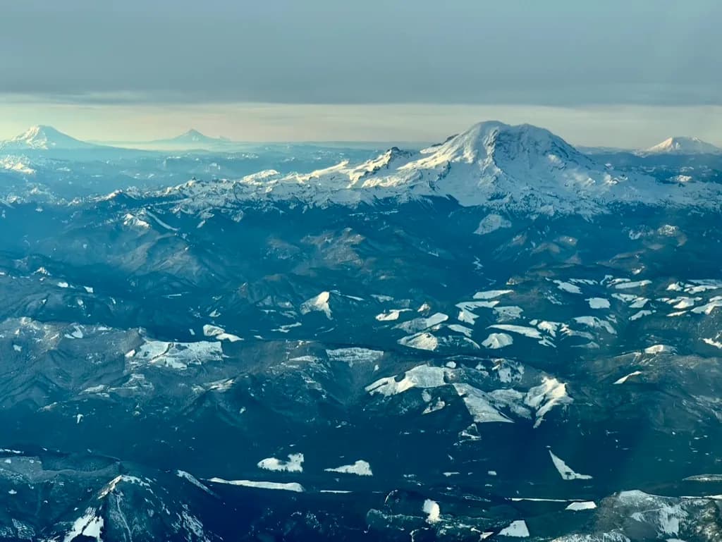 Majestic Peaks: A Serene Aerial View of Snow-Capped Mountains at Dusk