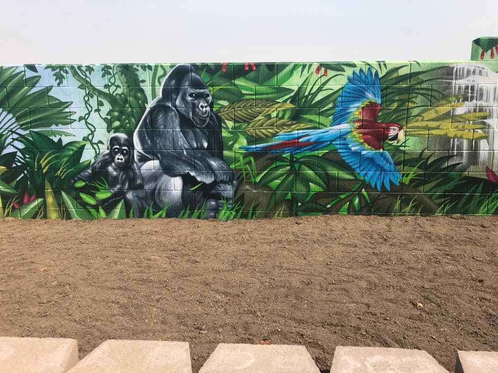 Jungle Harmony: A Vibrant Mural of Gorillas and Macaws in Lush Greenery