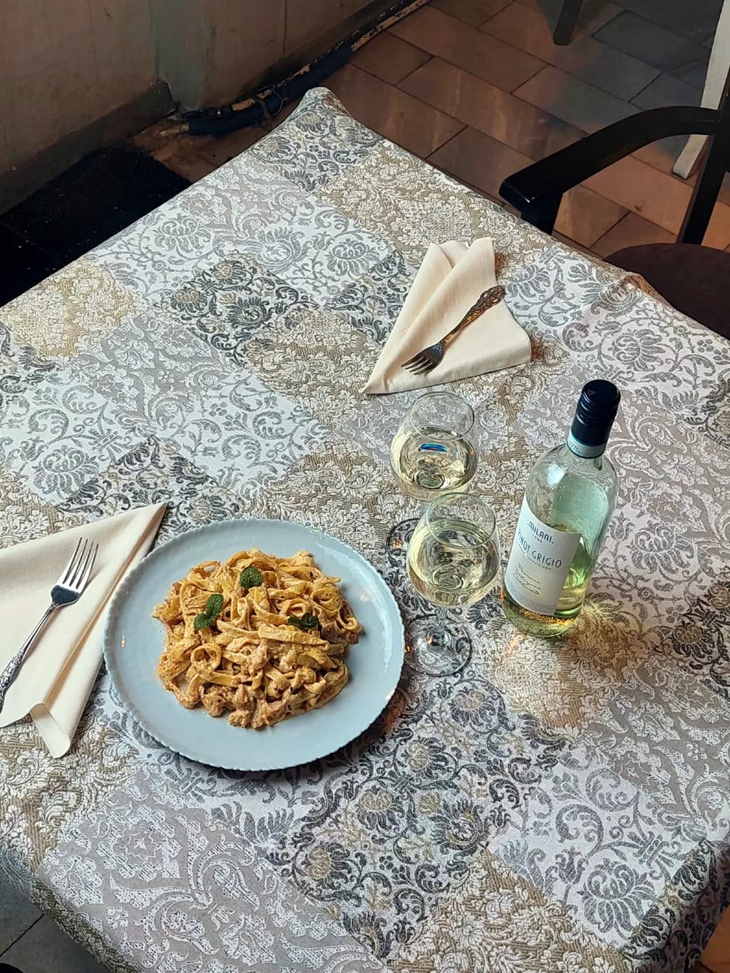 Culinary Elegance: A Romantic Table Setting with Creamy Pasta and Crisp White Wine