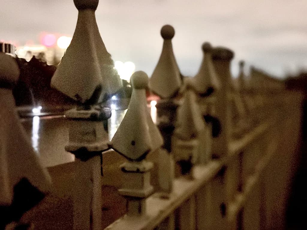 Whispers of the Night: A Serene Fence Reflection in Urban Light
