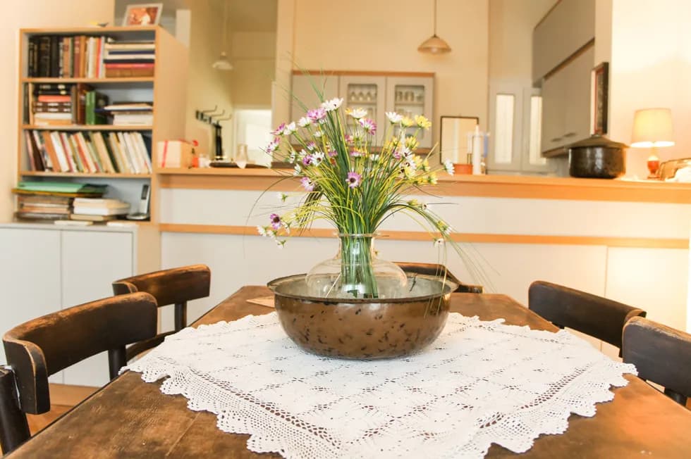 Serenity in Bloom: A Cozy Dining Table Arrangement with Fresh Flowers and Vintage Charm