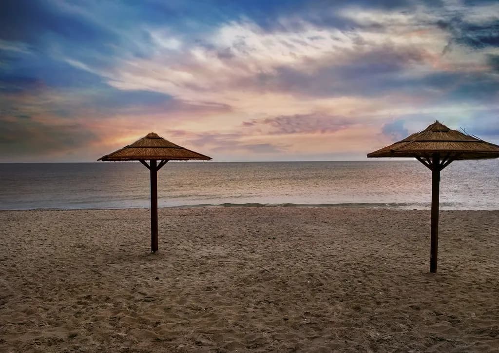 Serenity at Dusk: Two Umbrellas Embracing the Tranquil Shoreline