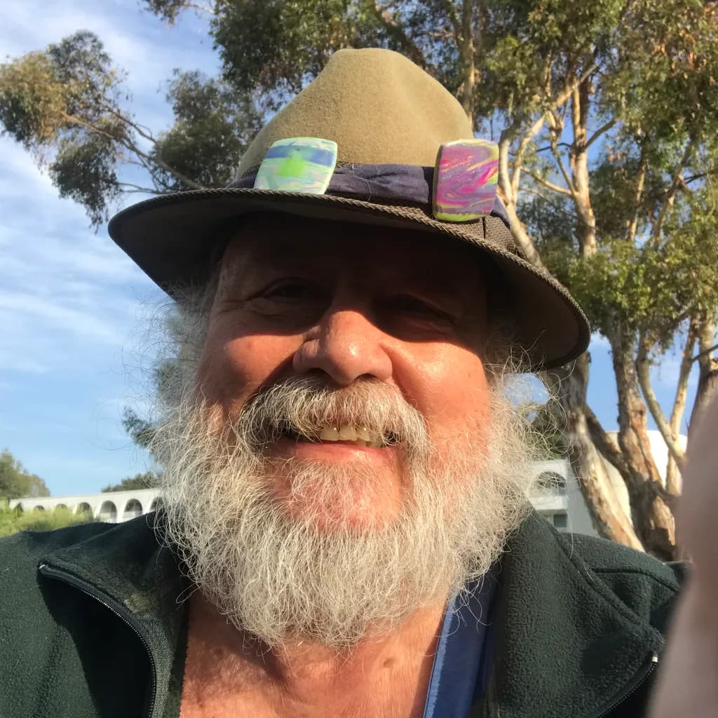 Joyful Portrait of a Bearded Man in a Hat Surrounded by Nature's Embrace