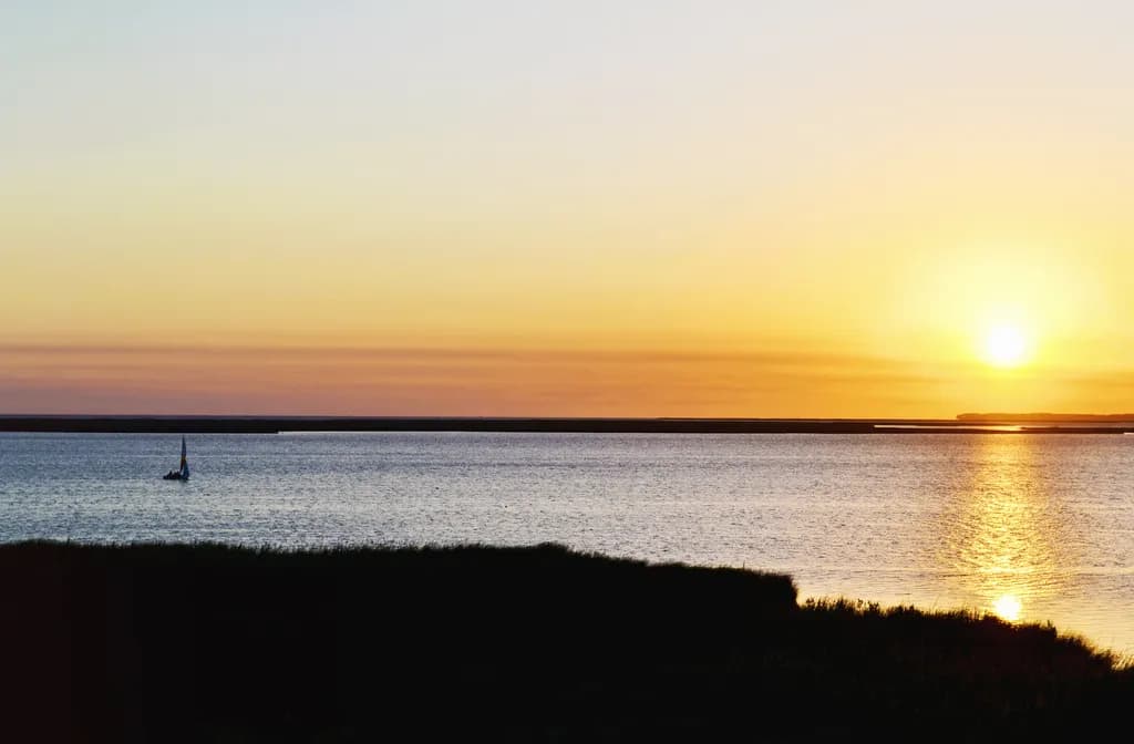 Serenity at Dusk: A Sailboat's Journey into the Golden Horizon