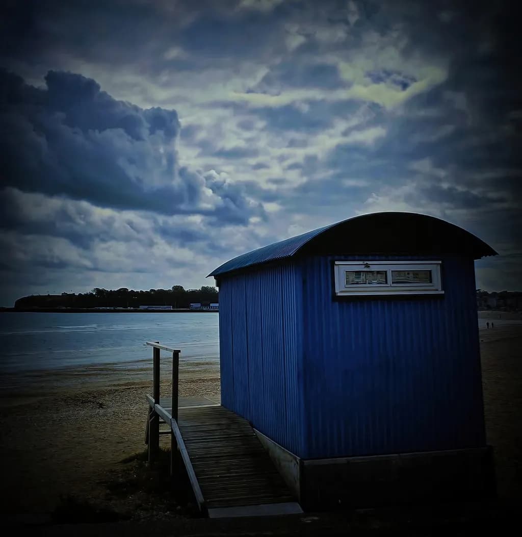 Whispers of the Shore: A Blue Retreat Beneath Stormy Skies