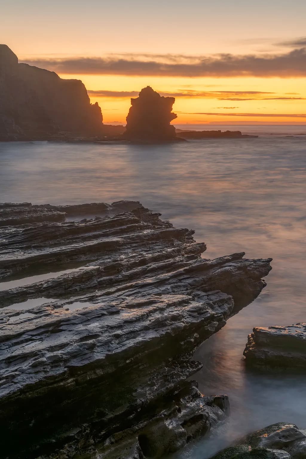 Whispers of the Ocean: A Serene Sunset Over Rocky Shores