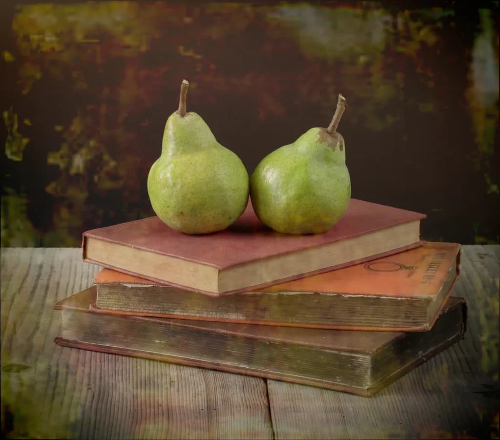 Vintage Still Life: Pears Resting on Weathered Books