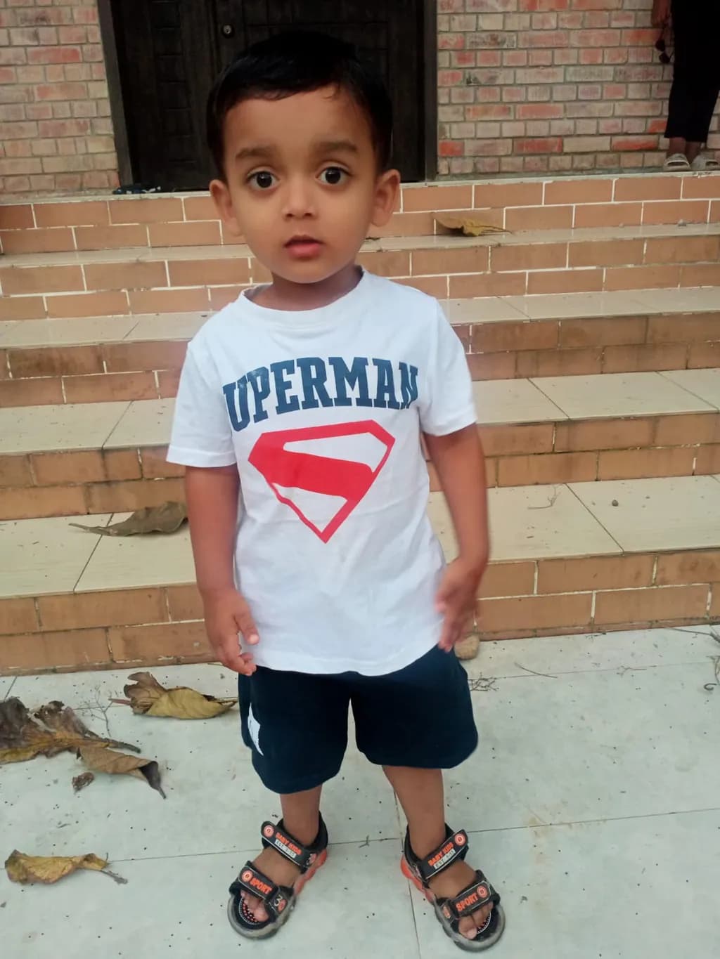 Curious Adventures: A Playful Child in Superman Attire on a Sunny Day