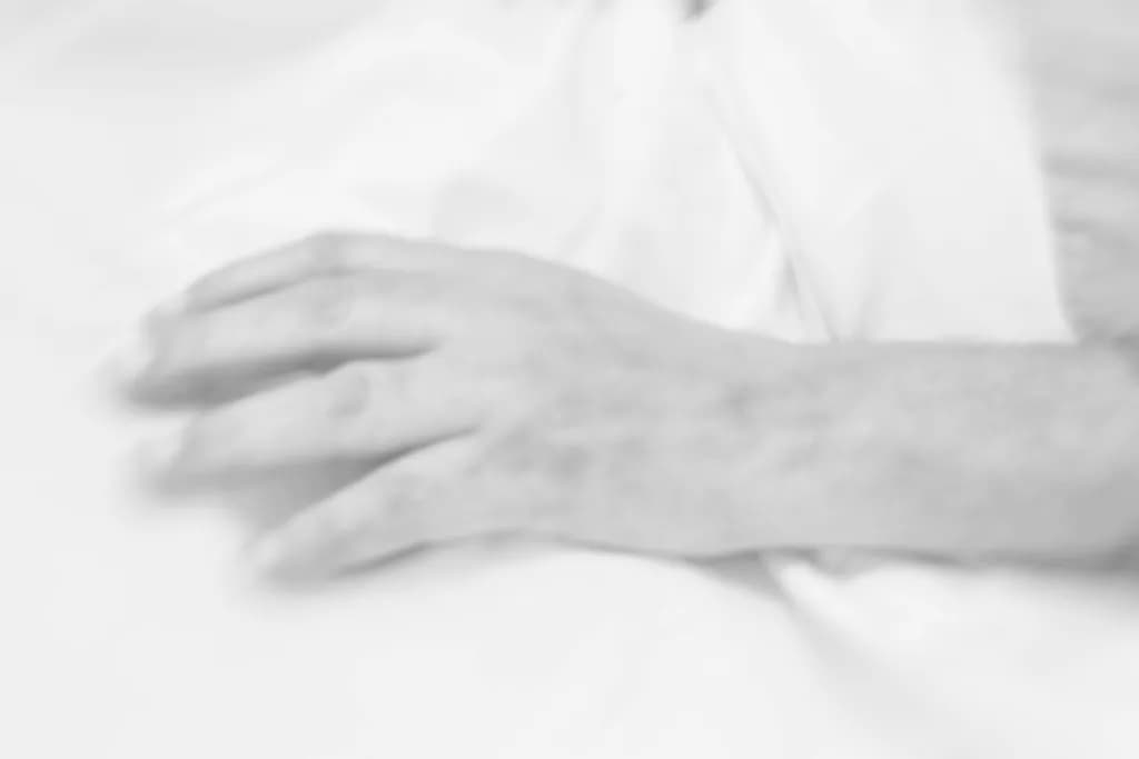 Whispers of Touch: A Delicate Hand in Soft White Blur