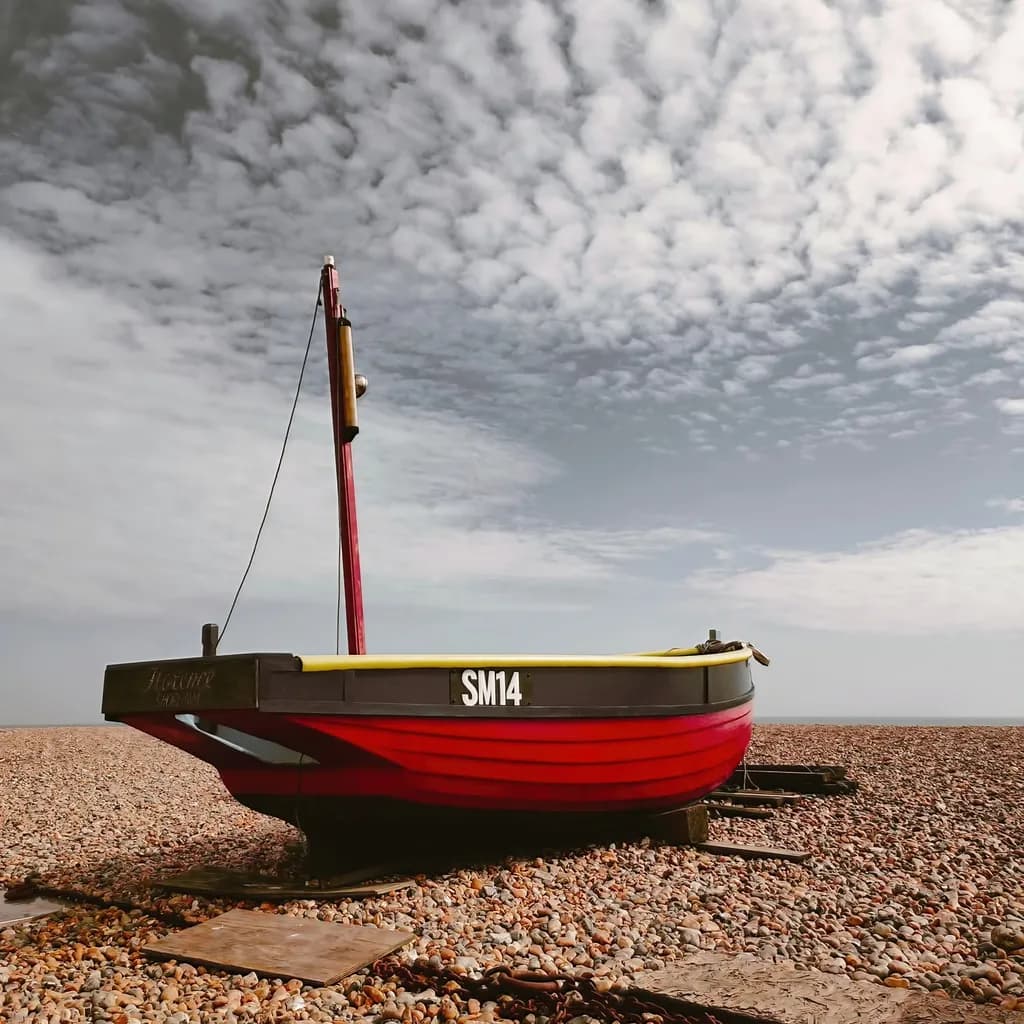 Harboring Dreams: A Vibrant Journey of the SM14 Boat on Pebbled Shores