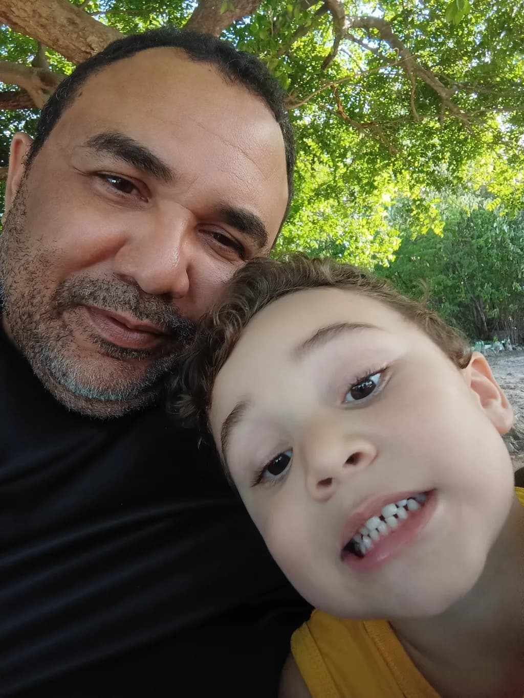 Joyful Moments: A Heartwarming Portrait of Father and Son Under the Canopy of Nature
