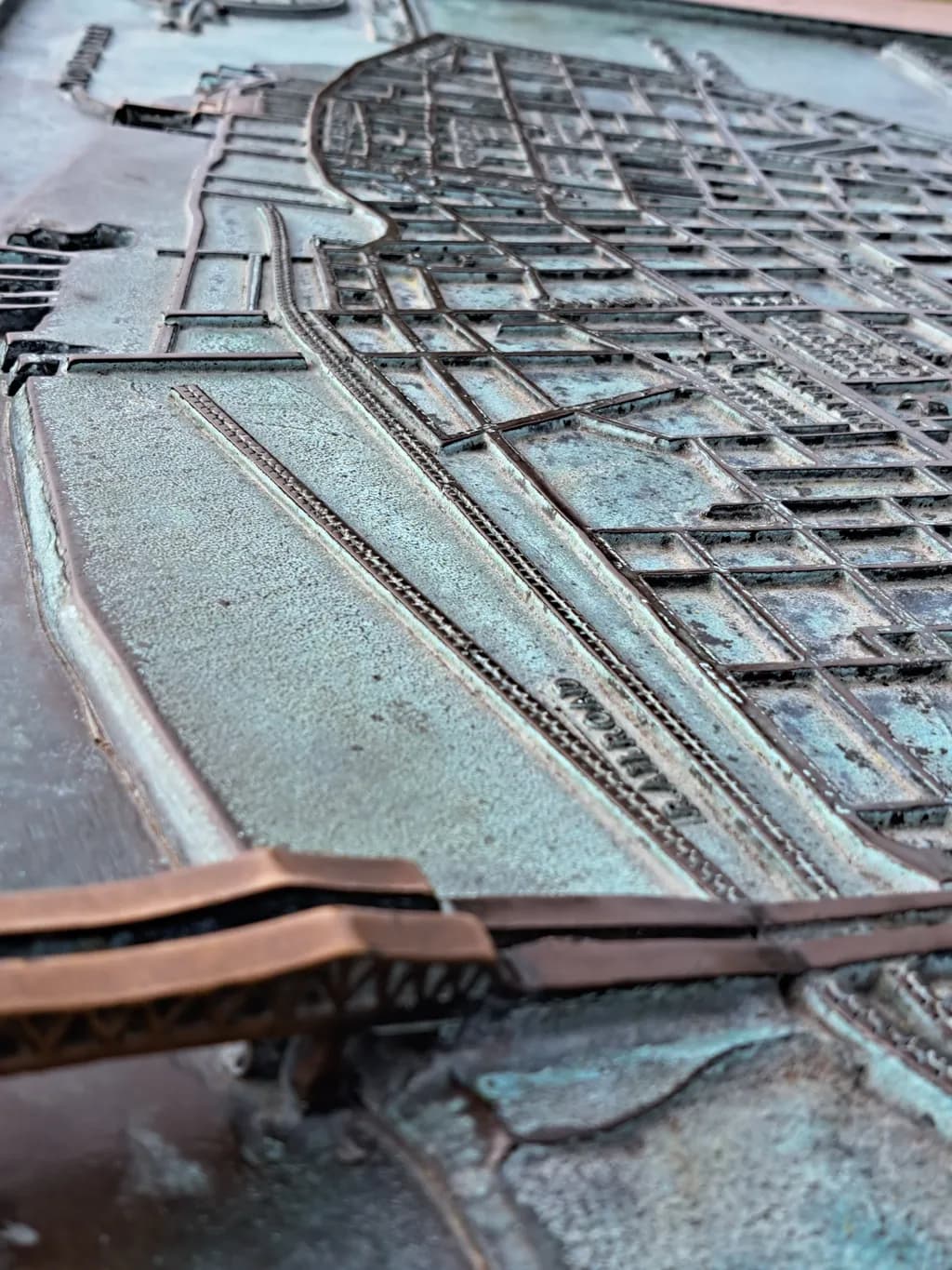 Urban Echoes: A Bronze Relief Map of City Life and Details