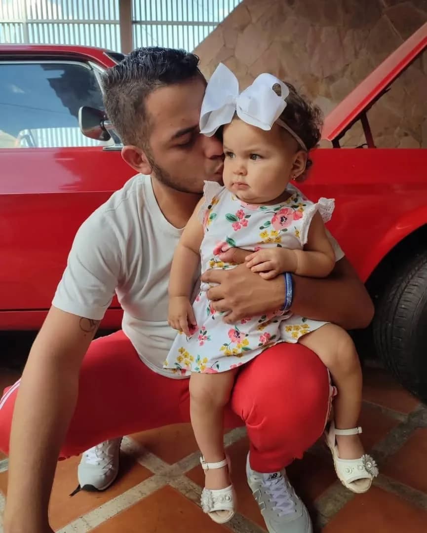 Cherished Moments: A Father’s Love Captured with His Little Princess in Front of a Classic Red Car
