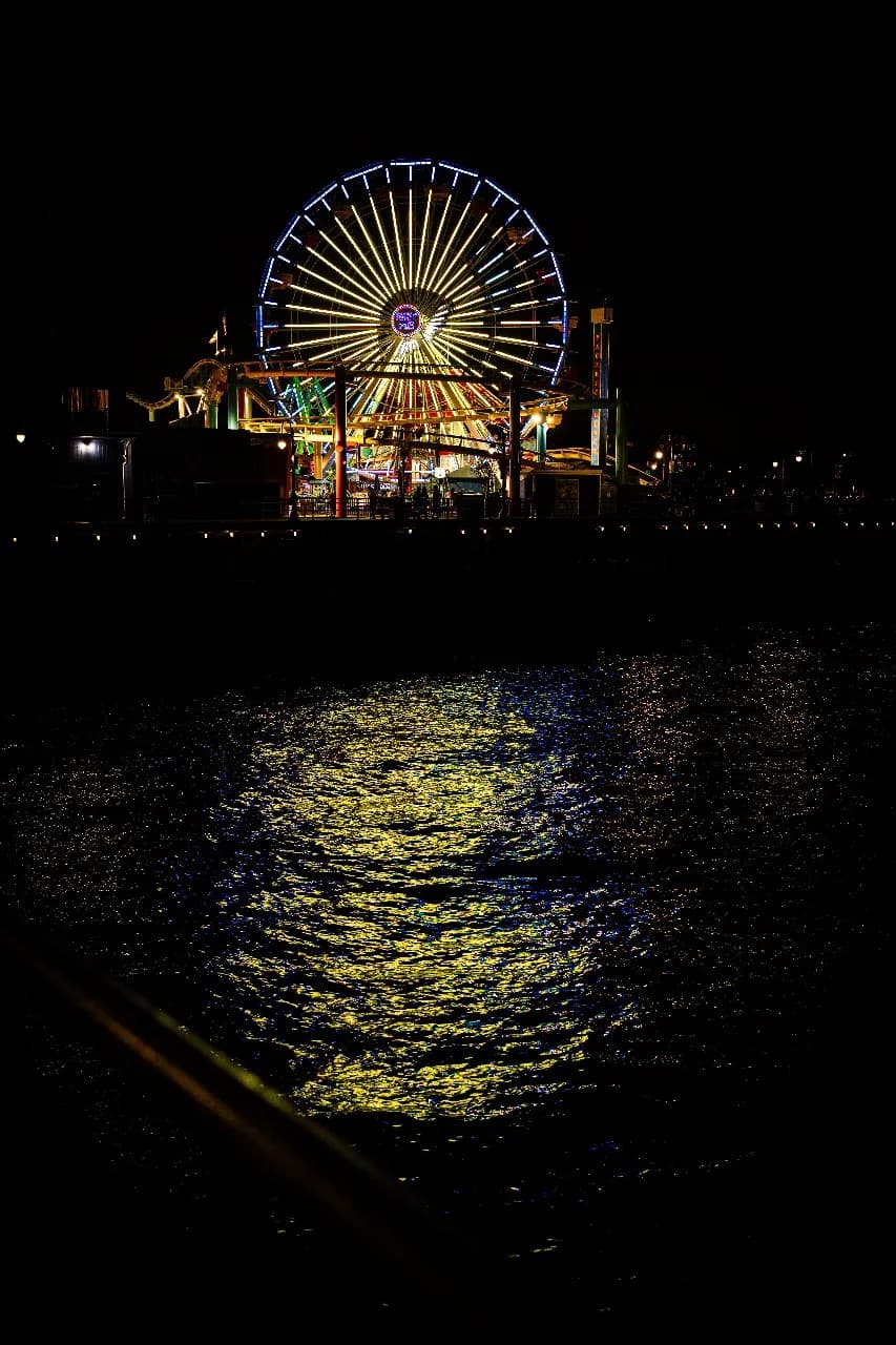 Whispers of Light: A Night at the Ferris Wheel by the Water