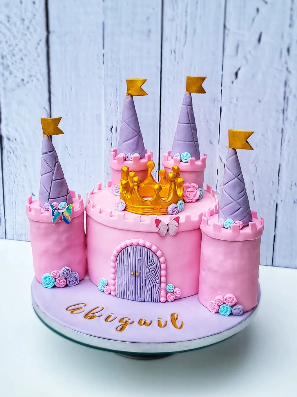 Whimsical Princess Castle Cake with Golden Crown and Colorful Floral Accents