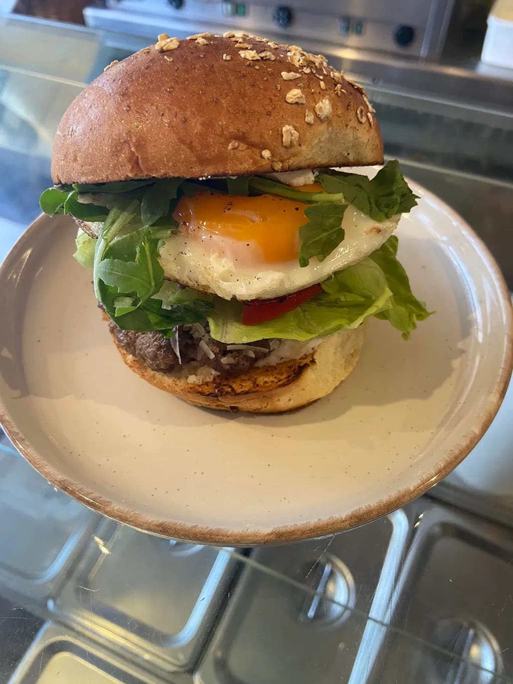 Savory Sunrise: A Gourmet Burger with Egg and Fresh Greens