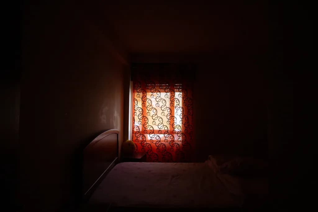 Whispers of Light: A Serene Bedroom Embraced by Shadows