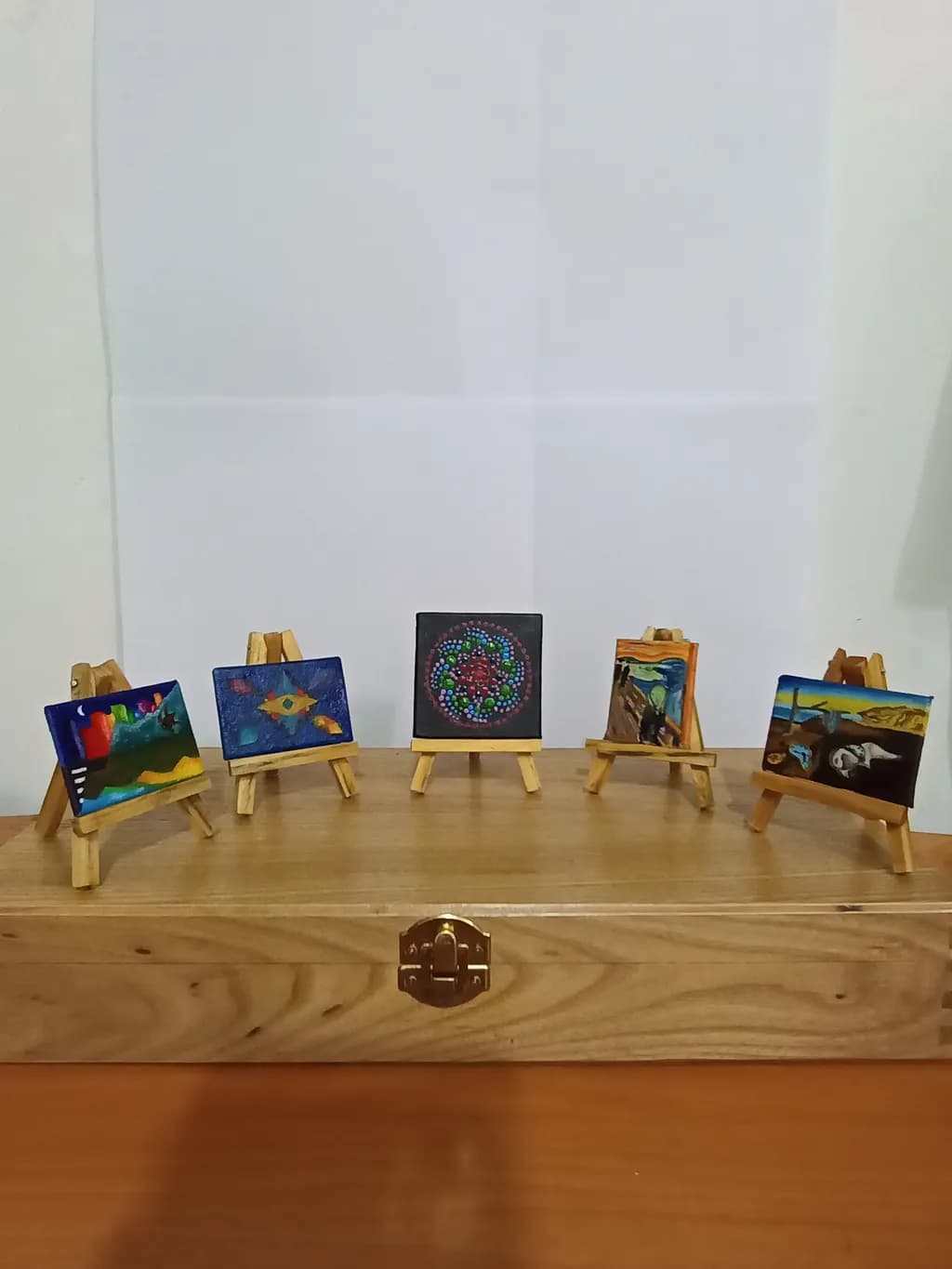 Miniature Masterpieces: A Collection of Colorful Wooden Paintings on Display Easels