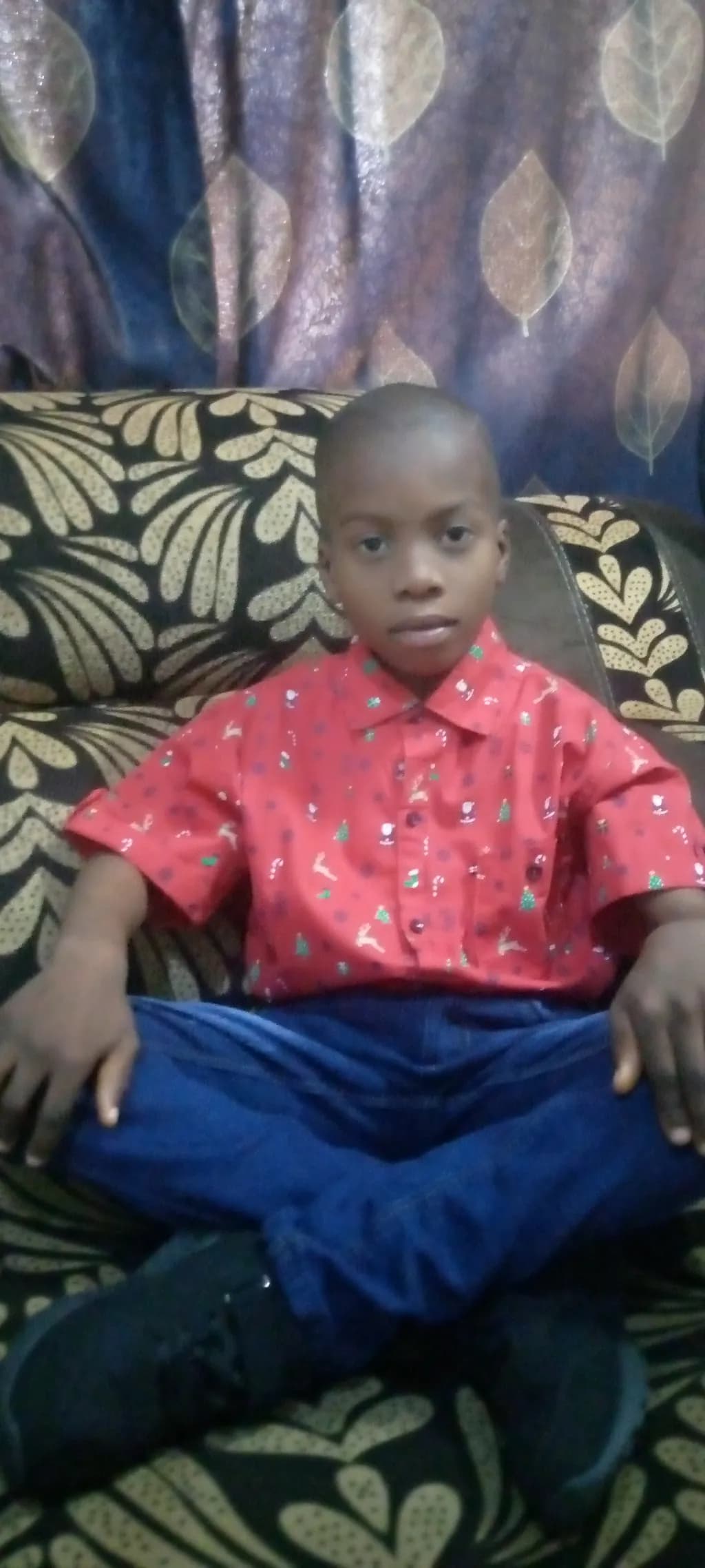 Vibrant Innocence: A Portrait of a Child in Red Casual Wear on a Cozy Sofa