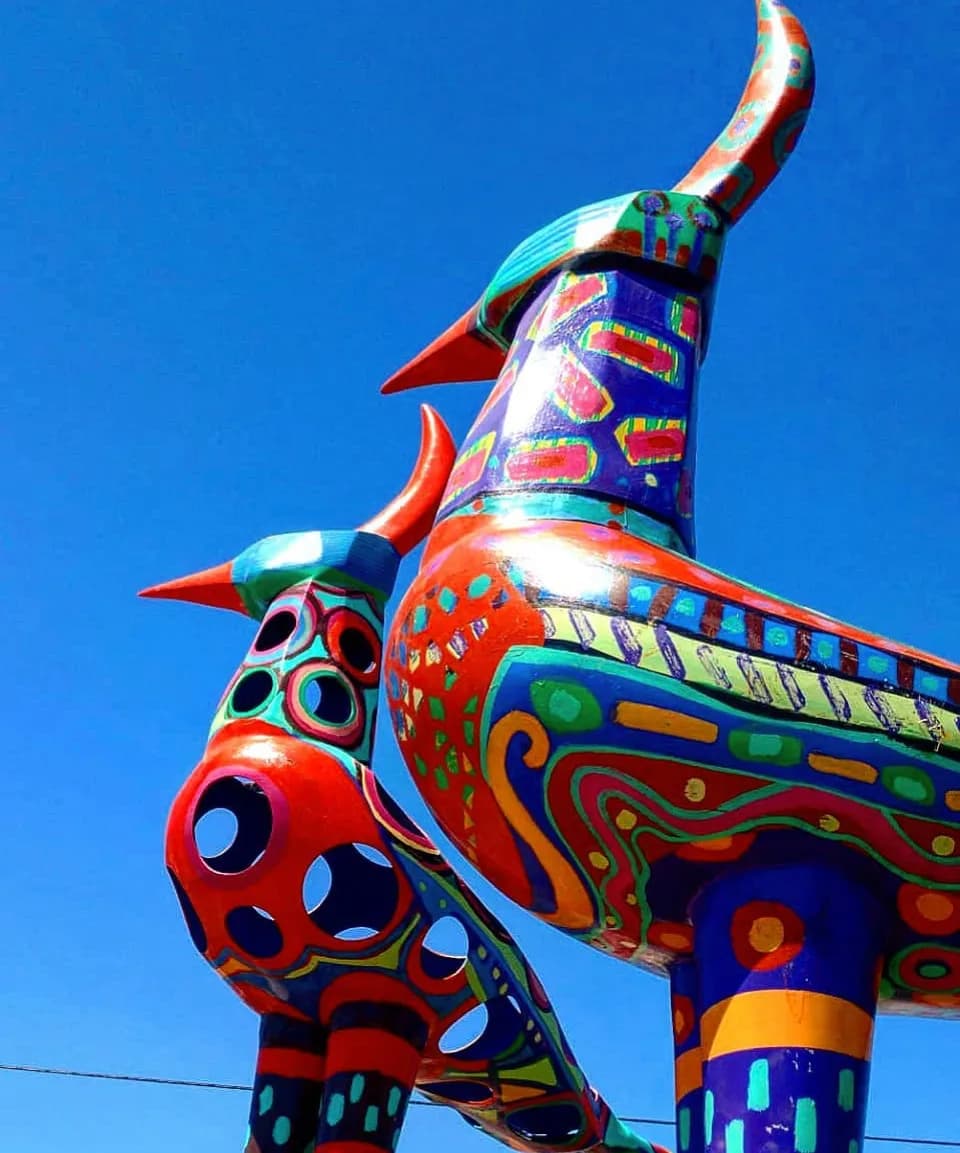 Vibrant Harmony: Colorful Bird Sculptures Against a Clear Blue Sky