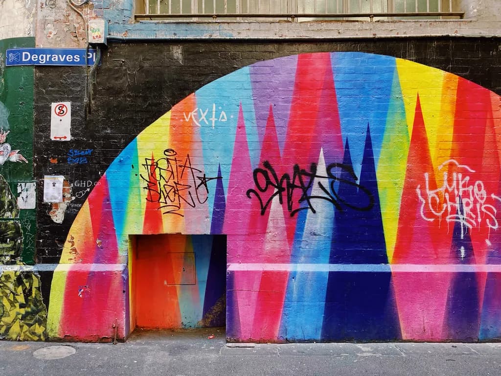 Vibrant Echoes – Degraves Place, Melbourne: A hidden doorway framed by a kaleidoscope of colors, where the whispers of the city meet the pulse of creativity. Here, the walls tell stories of fleeting moments, inviting you to pause and reflect on the beauty of the overlooked.