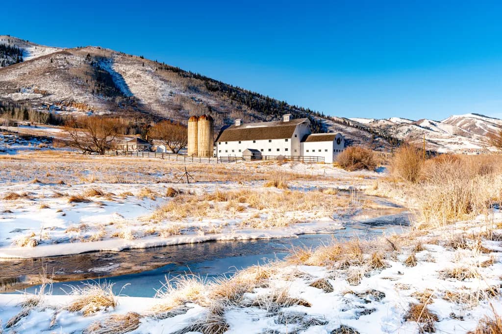 Serenity in Snow-Capped Mountains: A Tranquil Farm Landscape at Dawn