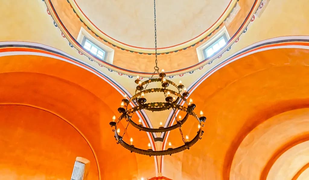 Illuminated Elegance: A Chandelier's Dance Beneath Curved Orange Arches