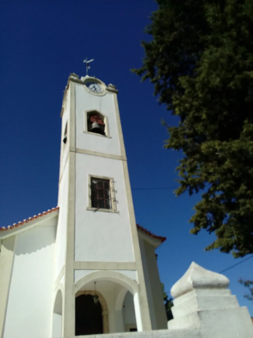 Whispers of Time: The Majestic Bell Tower Against a Clear Blue Sky