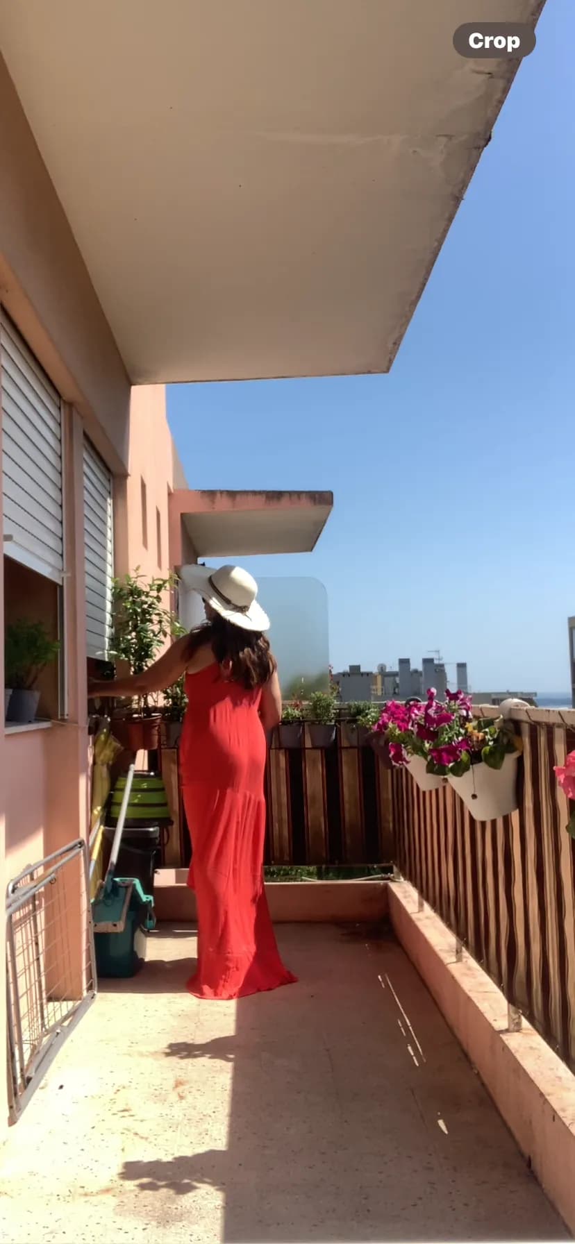 Balcony Bliss: Embracing Sunlit Serenity in a Flowing Red Dress