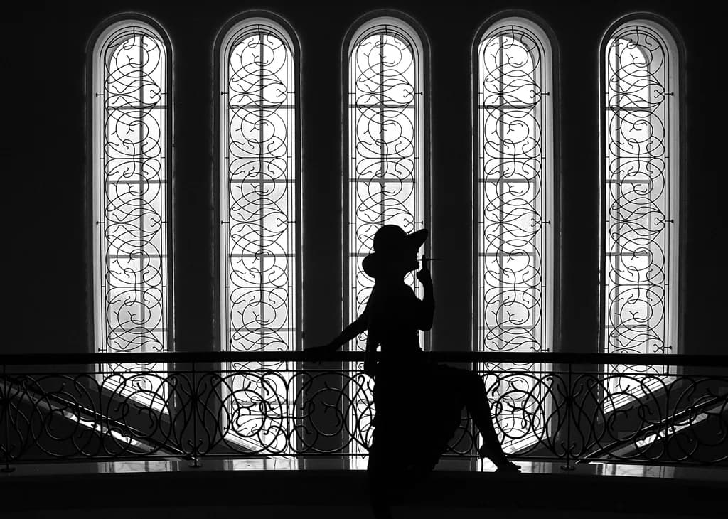 Elegance in Silhouette: A Fashionable Pose Against Architectural Grace