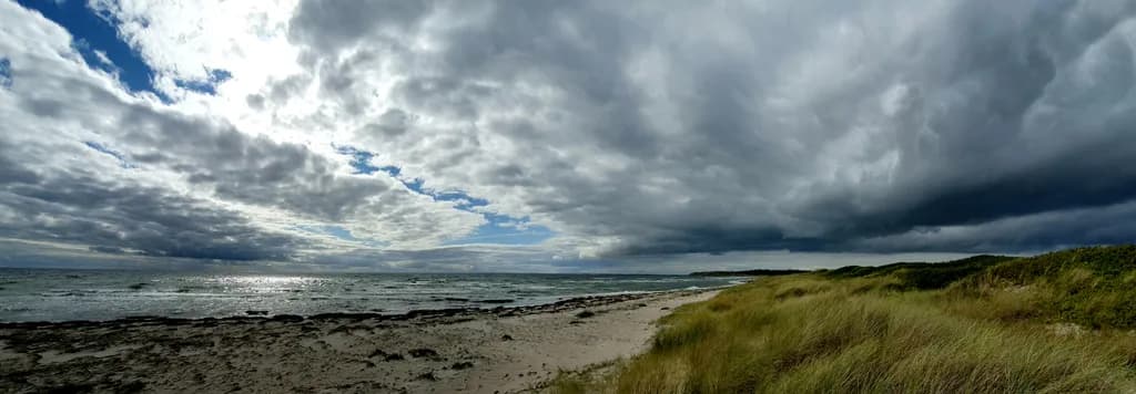 Serenity at the Shore: A Tranquil Beach Landscape Under Dramatic Skies