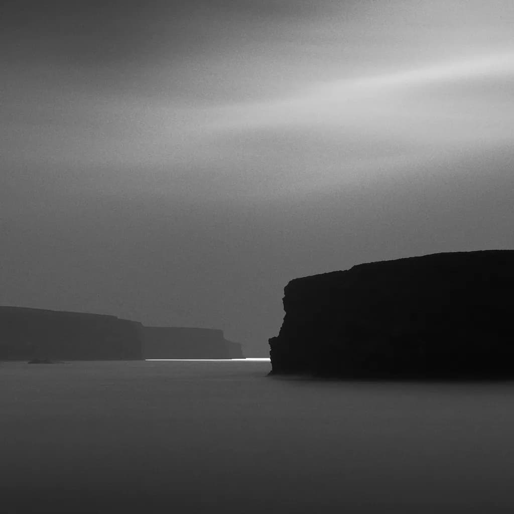 Whispers of the Monochrome Sea: A Serene Landscape of Mystical Cliffs and Water