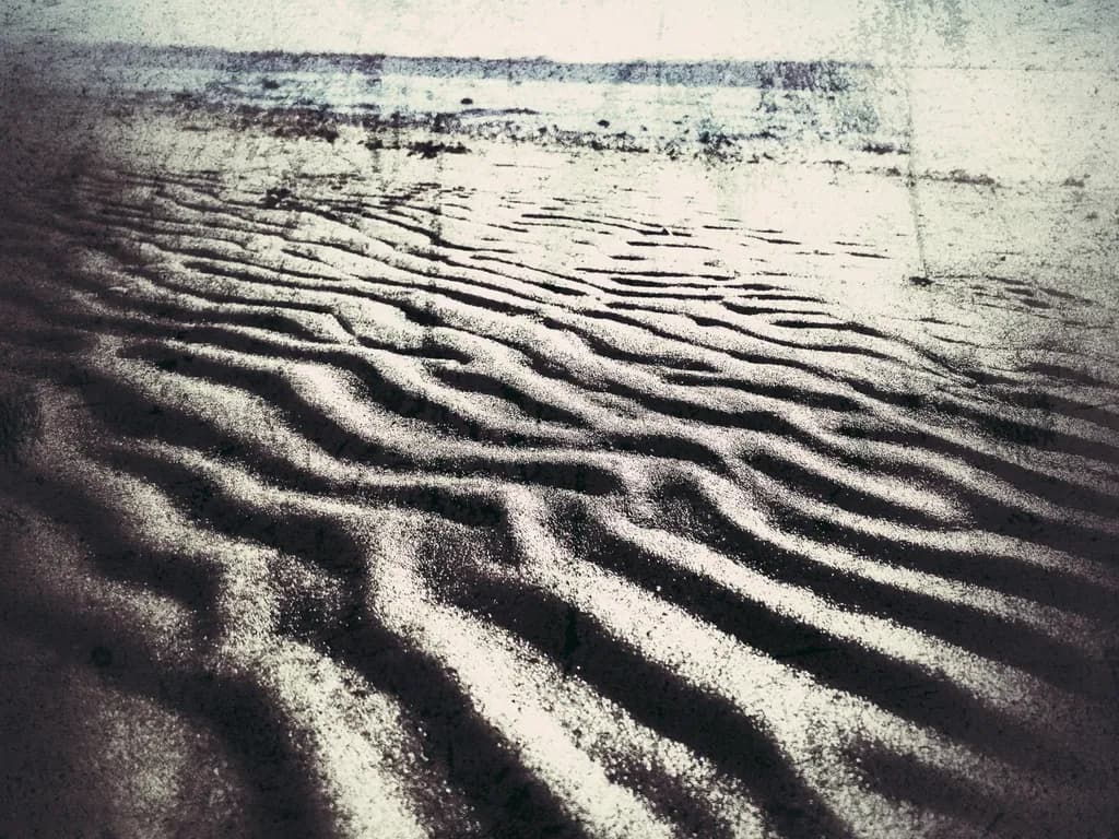 Whispers of the Shore: Textured Sands Beneath a Gentle Tide