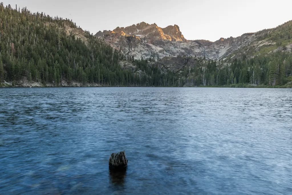 Whispers of Serenity: A Tranquil Lake at Dusk Amidst Majestic Peaks