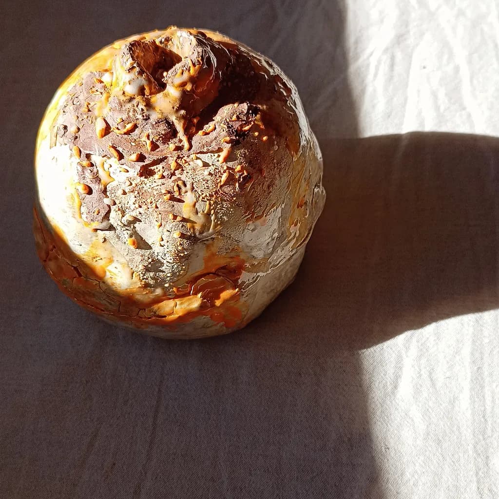 Whispers of Earth: A Textured Ceramic Sphere Embracing Nature's Palette