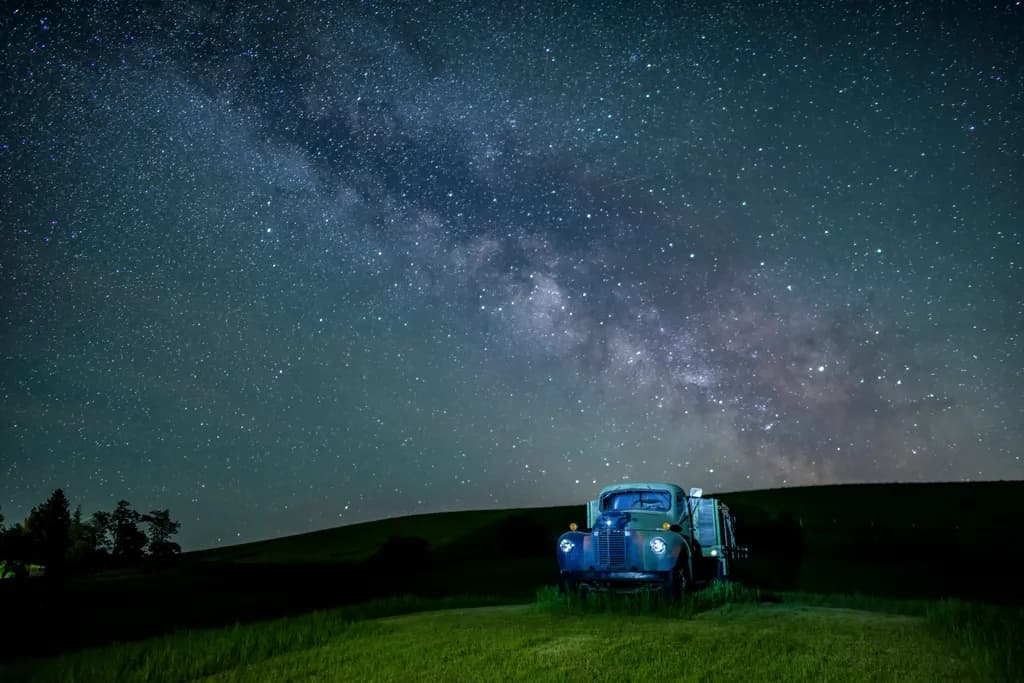 Whispers of the Galaxy: A Serene Nightscape with a Vintage Truck Under the Stars