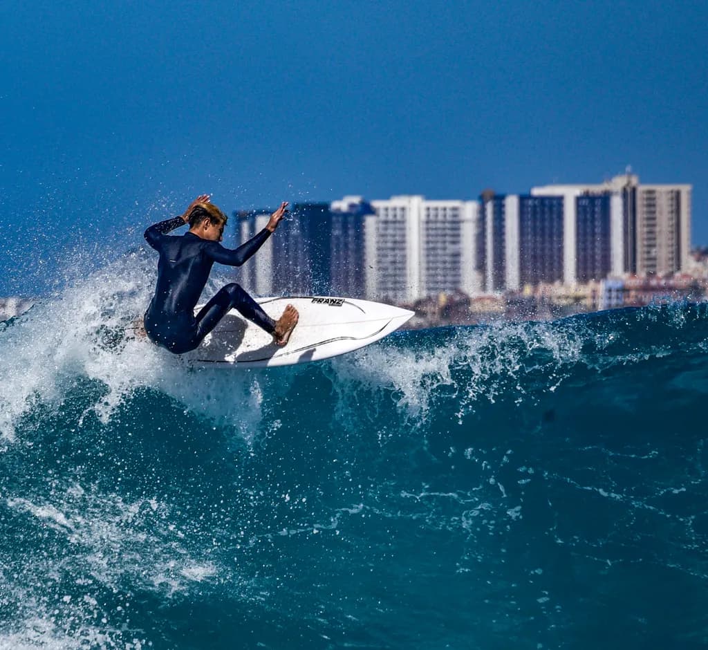 Riding the Wave: A Surfer's Dance Against the Urban Horizon