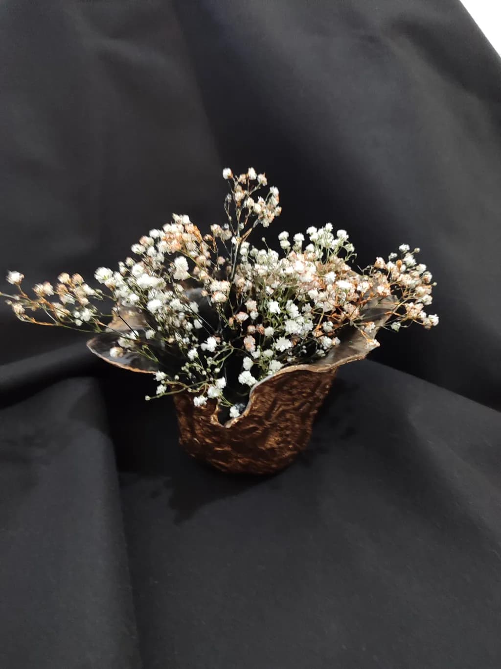 Whispers of Nature: Delicate Floral Arrangement in a Rustic Vessel