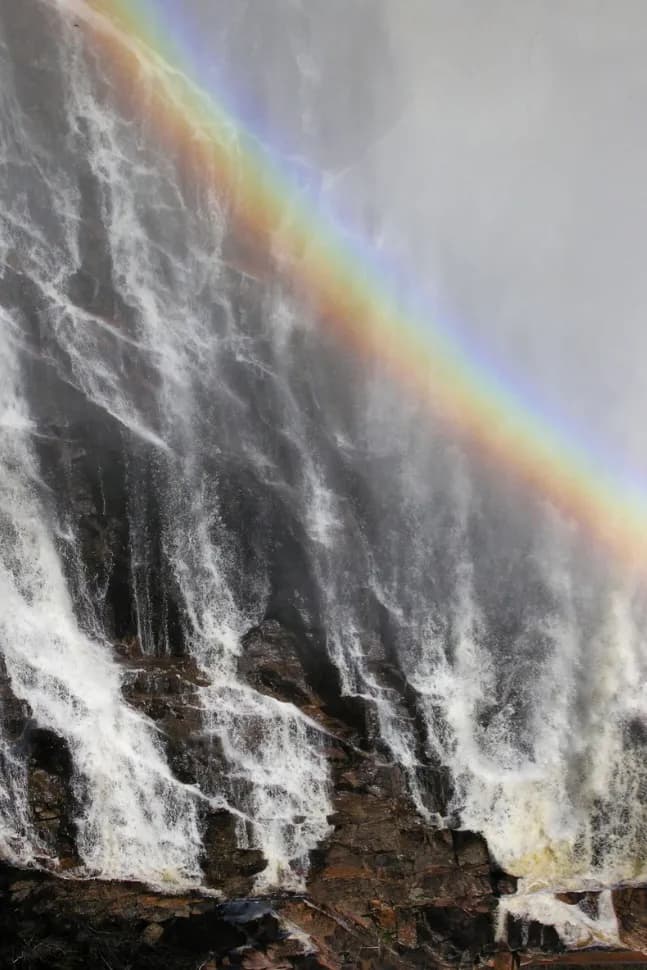 Whispers of the Waterfall: A Rainbow's Embrace in Nature's Splendor