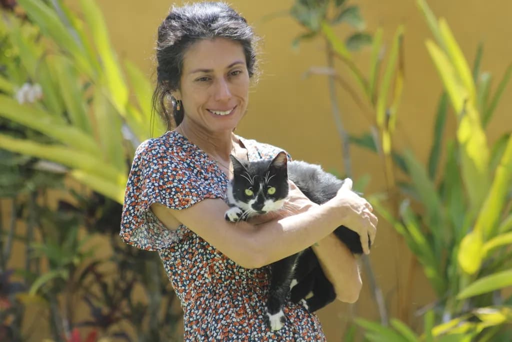 Whispers of Joy: A Woman and Her Cat in a Sunlit Garden