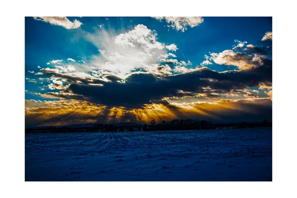 Ethereal Winter Sunset: A Dance of Light and Shadow Over Snowy Fields