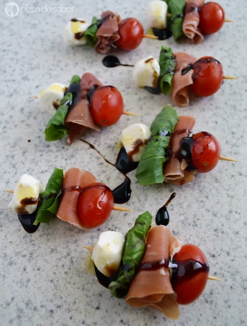Savory Skewers: A Colorful Medley of Prosciutto, Cherry Tomatoes, and Fresh Basil Drizzled with Balsamic Glaze