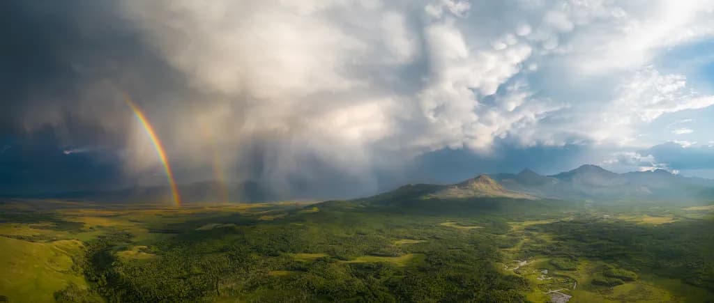 Whispers of Nature: A Dance of Rainbows and Storms Over Verdant Valleys