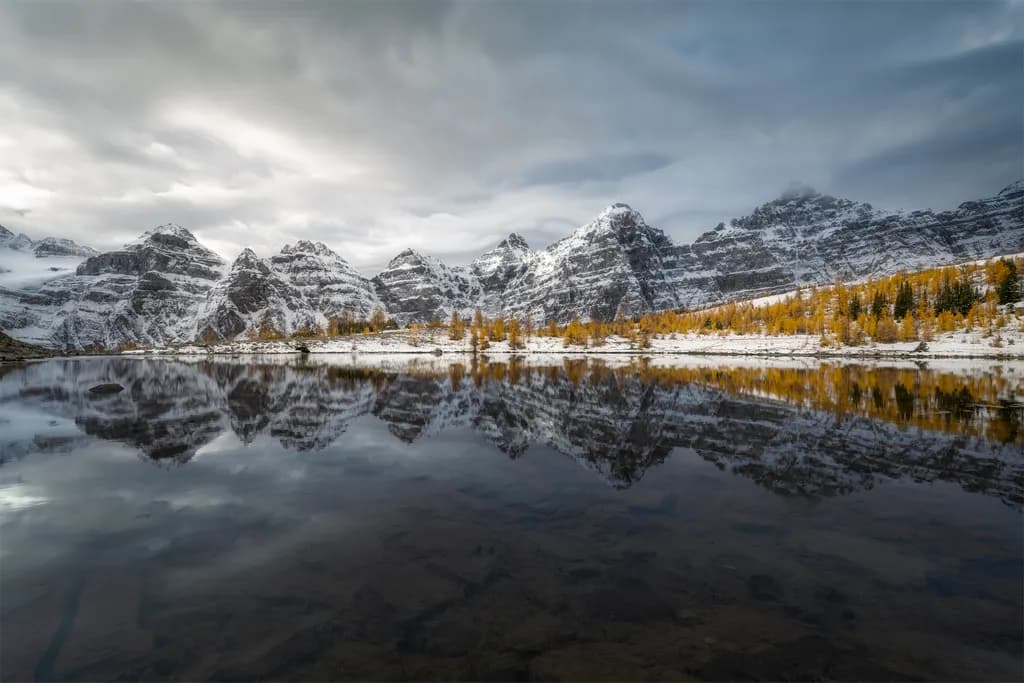 Whispers of Autumn: Reflections on a Snow-Capped Lake